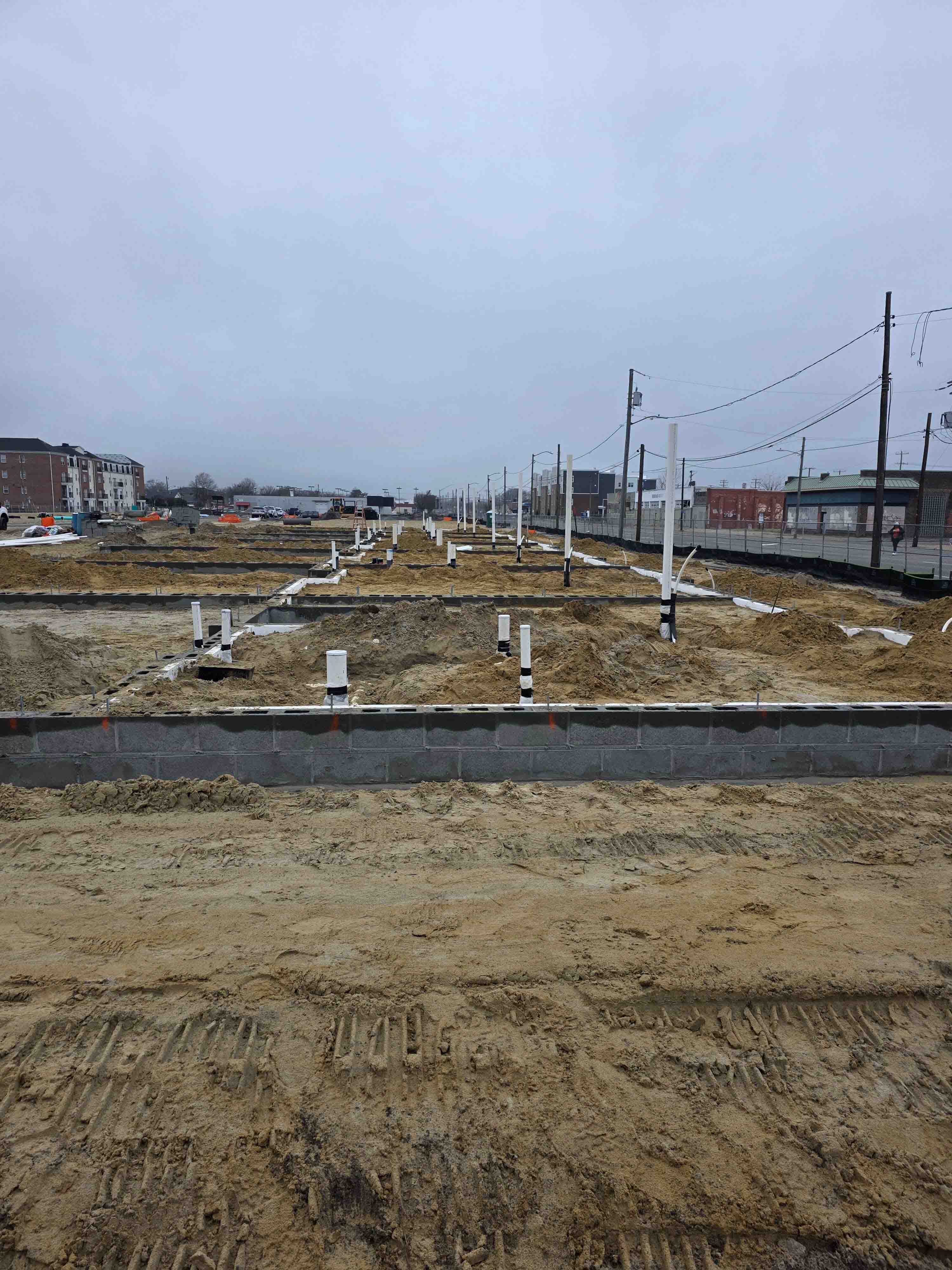 New construction site with foundation walls and plumbing stub-outs